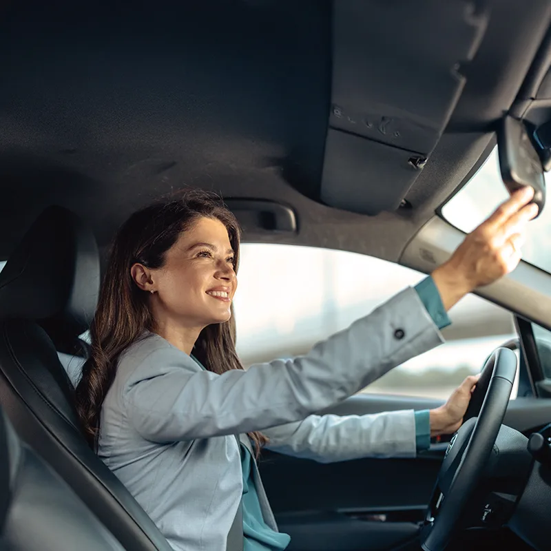 Confident businesswoman driving in her car with a smile