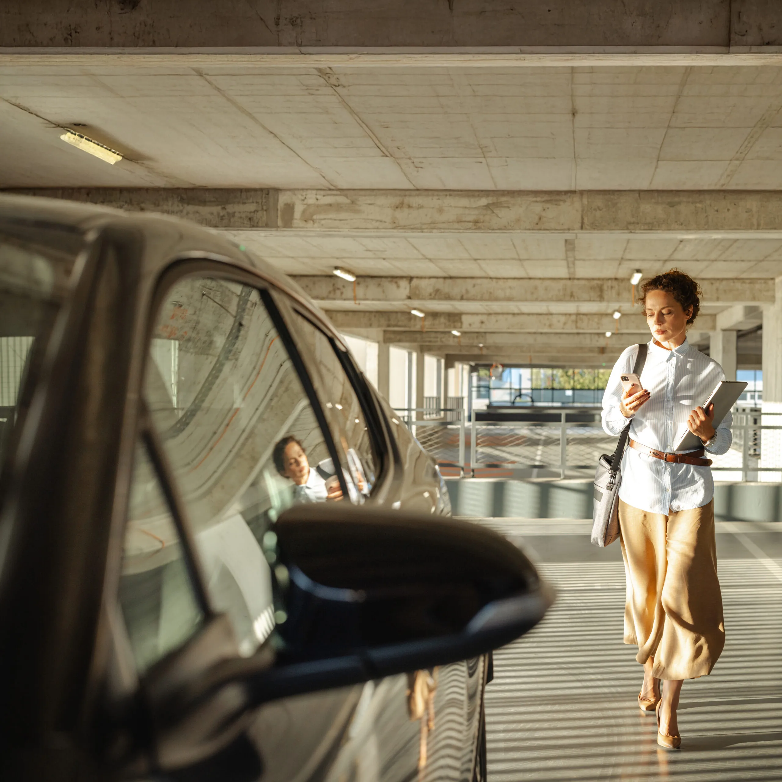 Mid adult beautiful woman approaches her car in the parking garage
